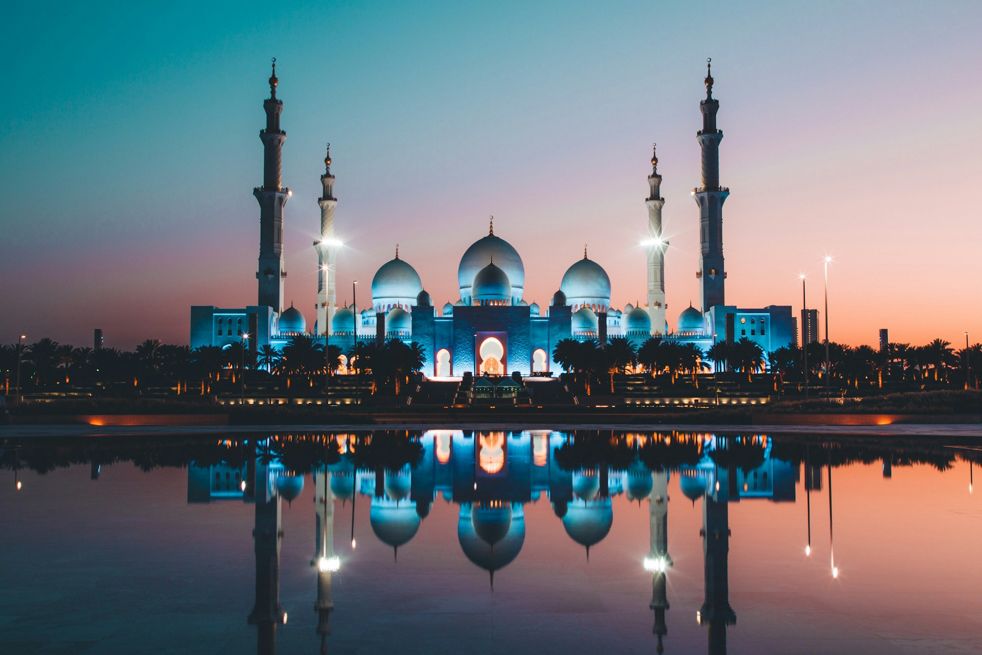 Grand mosque at dusk, reflected in still water